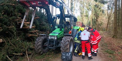 Glimpflicher Ausgang eines Forstunfalls. Über Notruf wurde gemeldet, dass eine Person unter einem Traktor eingeklemmt sei. Tatsächlich war der Mann vom Rückewagen gestürzt und hatte sich dabei verletzt, wurde aber nicht eingeklemmt.