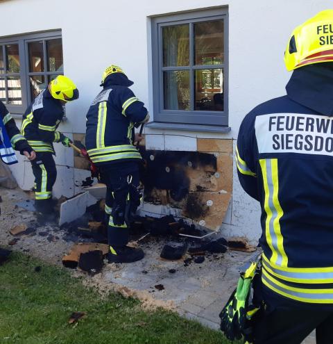 Ein Mann steht mit Wasser am Strahlrohr bereit