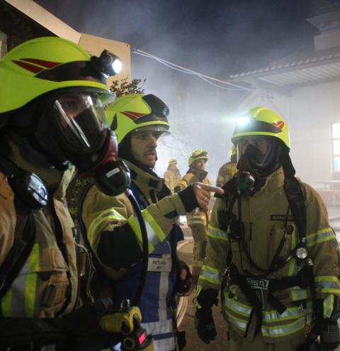 Feuerwehrmänner mit Atemschutzgeräten erhalten Anweisungen